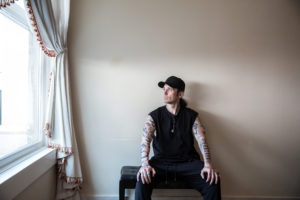 Damien Echols sitting in a white room with white curtains